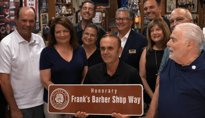 Frank Shemitraku përpara Frank's Barber Shop në Elmwood Park, Illinois, një biznes historik që drejtohet prej tij dhe është kthyer në simbol të komunitetit.